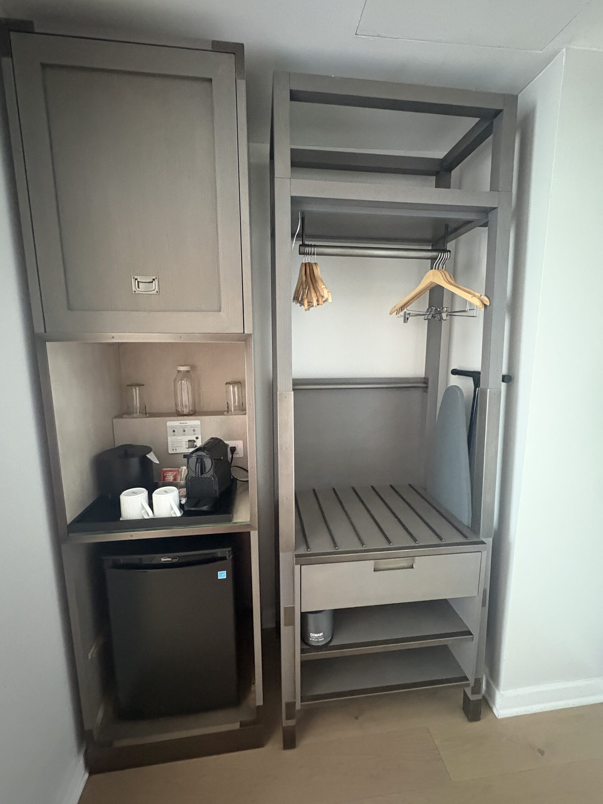 Closet with Nespresso machine, mini-fridge, and hangers at Canopy by Hilton Washington DC The Wharf