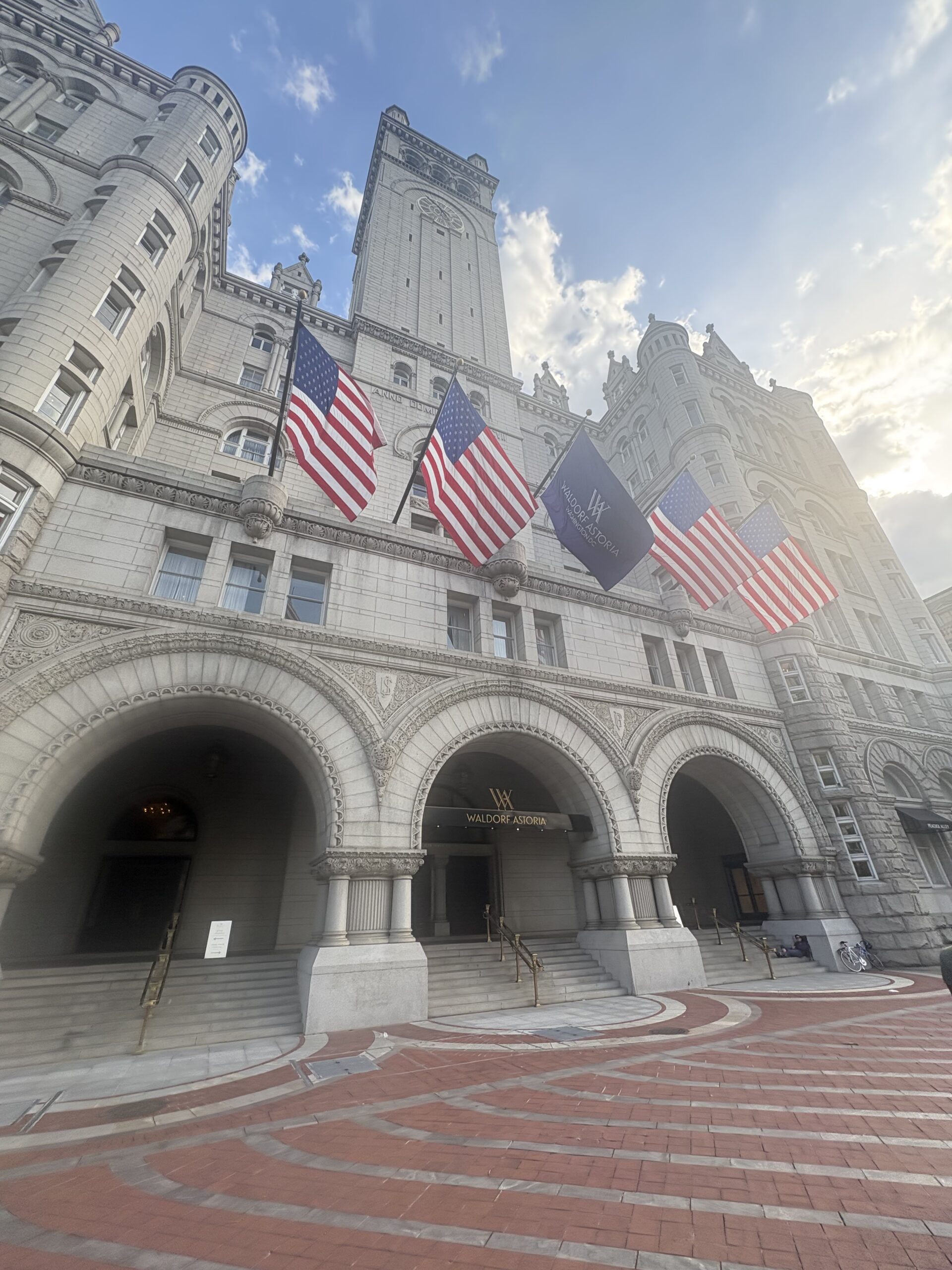 Waldorf Astoria Washington DC exterior with Old Post Office clock tower and American flags flying out front