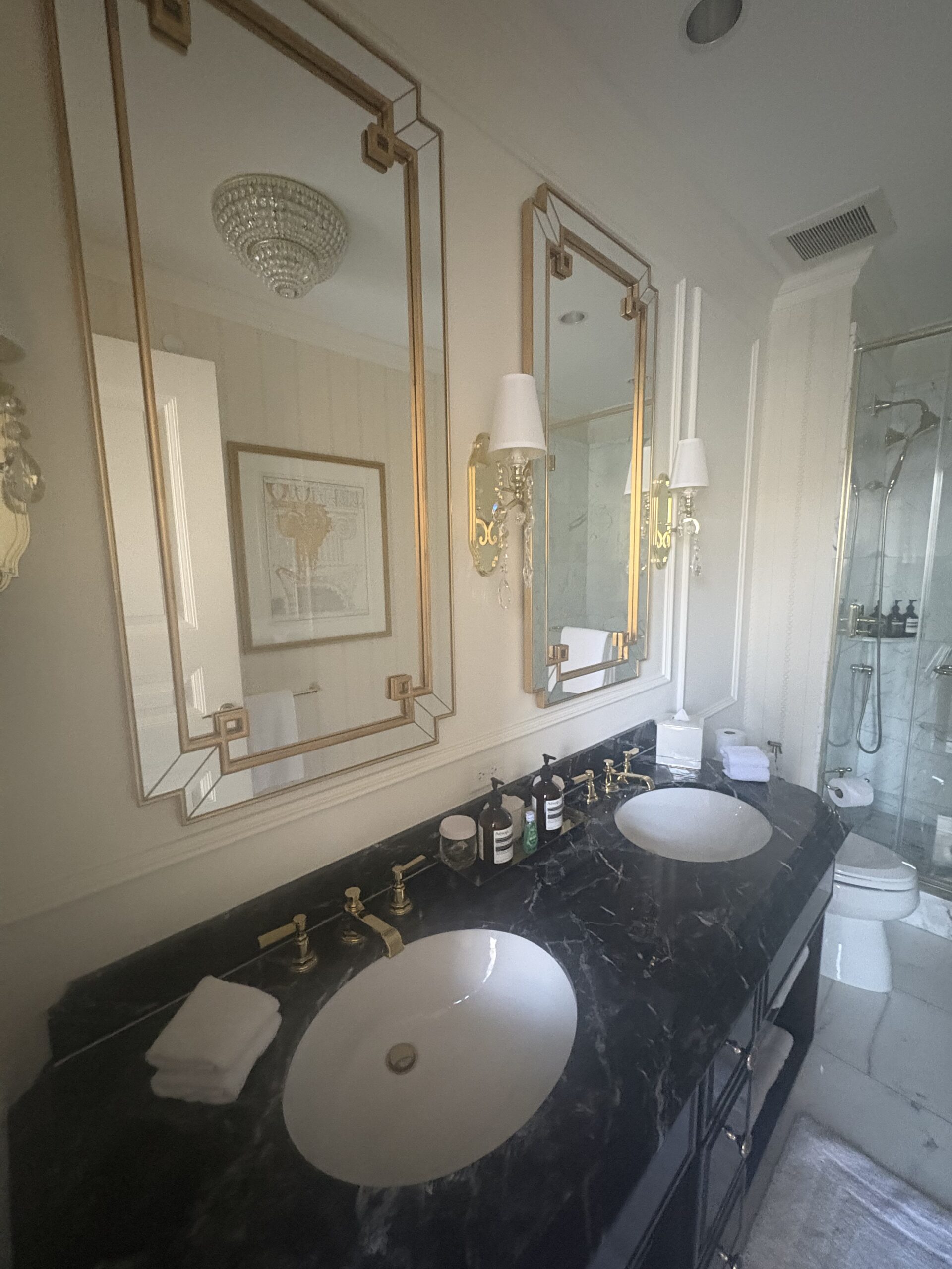 Black marble double vanity with gold-framed mirrors at Waldorf Astoria Washington DC
