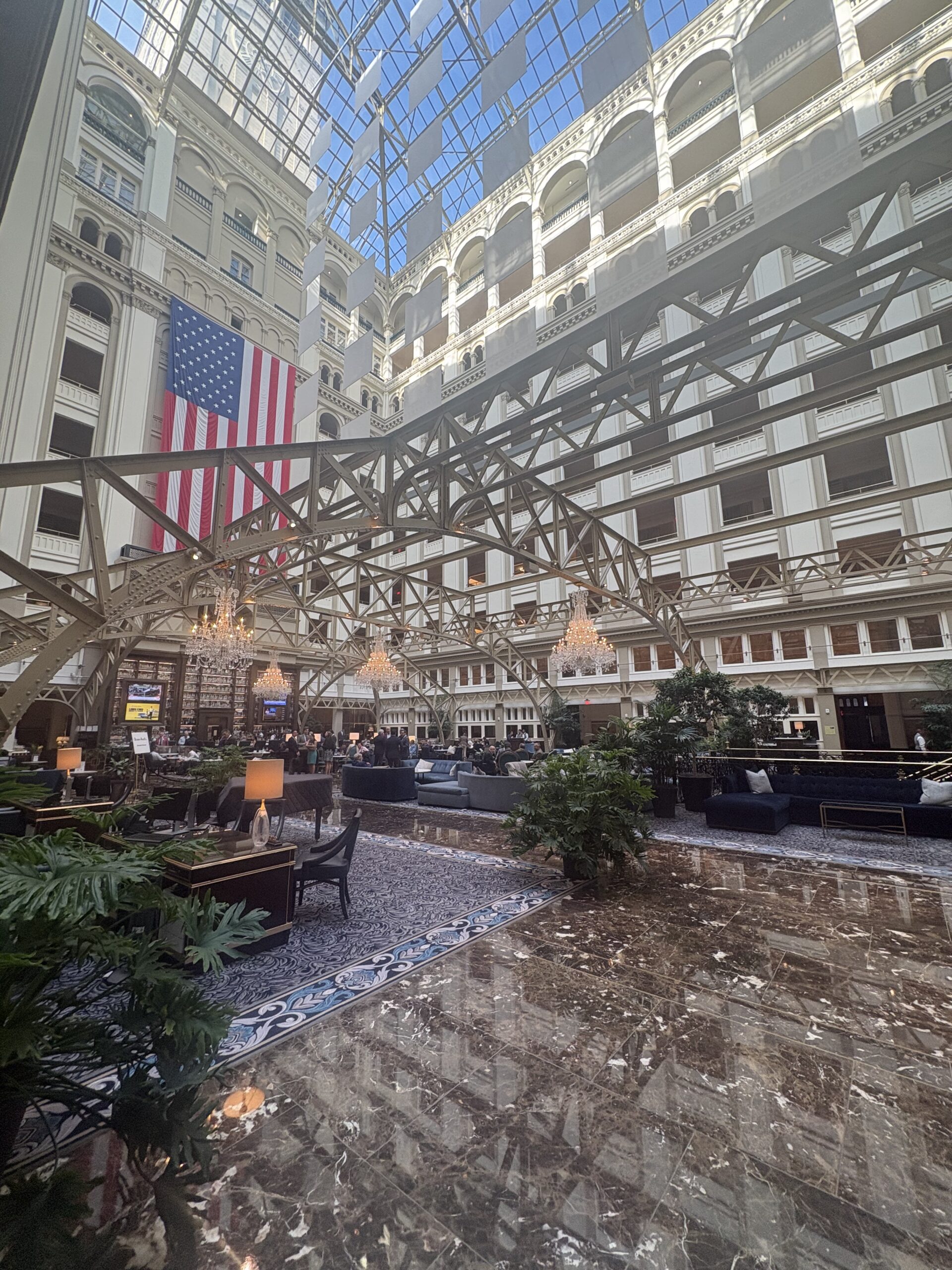 9-story glass atrium with skylight and large American flag at Waldorf Astoria Washington DC